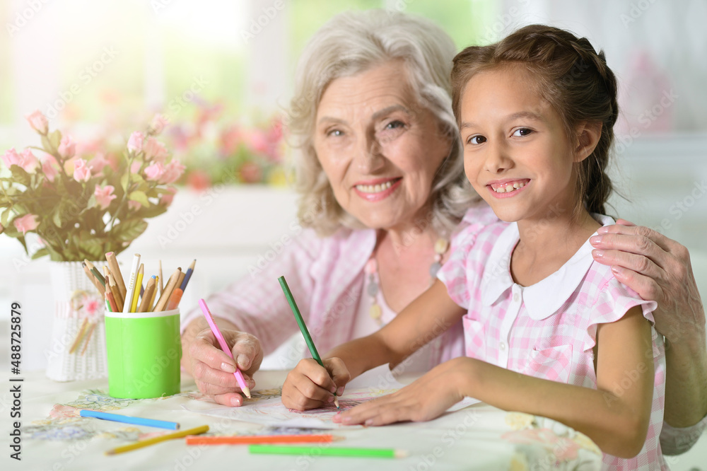 Portrait of a cute little girl drawing with her grandmother Portrait of a cute little girl drawing with her grandmother
