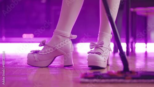 Maid wearing pink lolita platform shoes mop home floor close-up