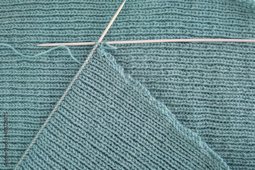 Knitting by hand. Handiwork. Knitted surface. Spokes. Warm handmade knitwear. Warm knitting for winter. © Natalya