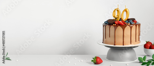 Photography Banner with Chocolate birthday cake with berries, cookies and number ninety gold