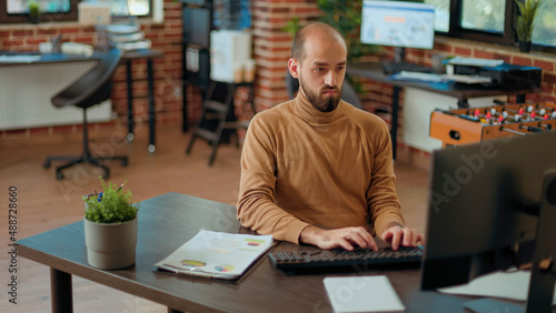 Company accountant analyzing charts on documents and working on computer to plan financial growth. Project manager using economy statistics to develop professional business network.