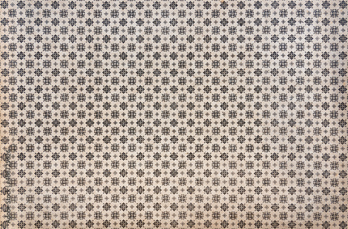 Floral pattern on vintage endpaper, repeating small black ornaments on beige background photo