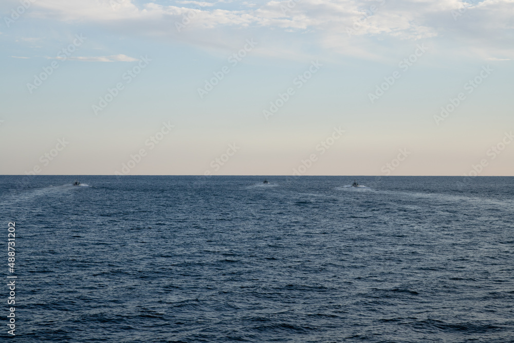 Obraz premium 夕暮れの柔らかな光に包まれる海と漁船