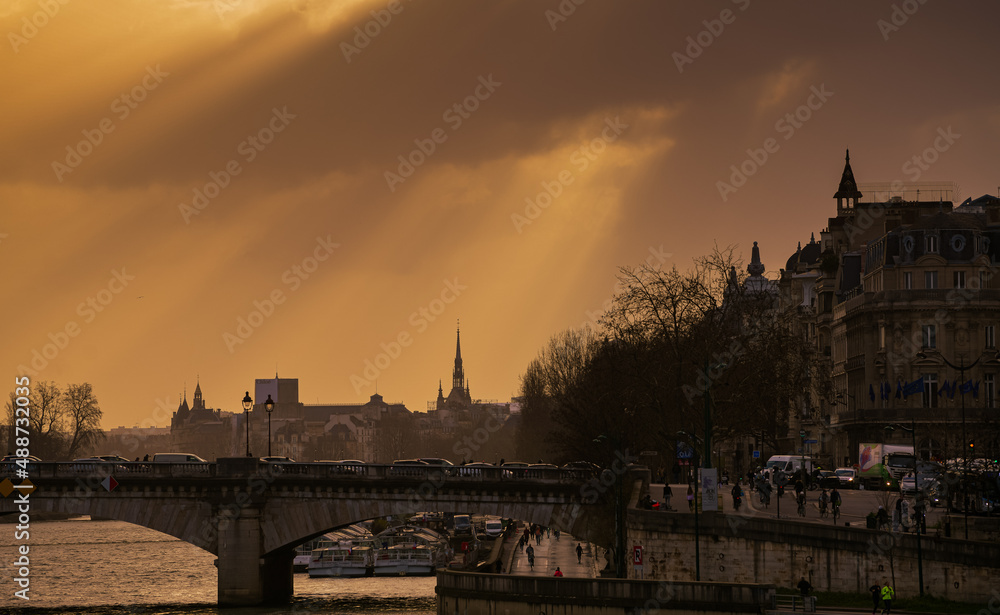 Obraz premium Dramatic sunrise over the streets of Paris. Morning rush hour traffic on the boulevards next to Seine River. France, 2022.