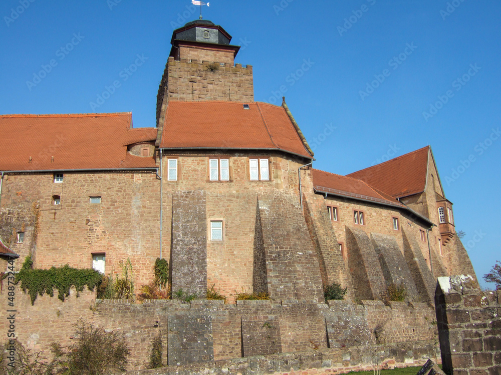 View of the youth hostel and Breuberg Castle. The old walls and the castle tower are surrounded by clear blue sky
