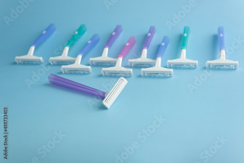 Set of multi-colored disposable razors on a blue background