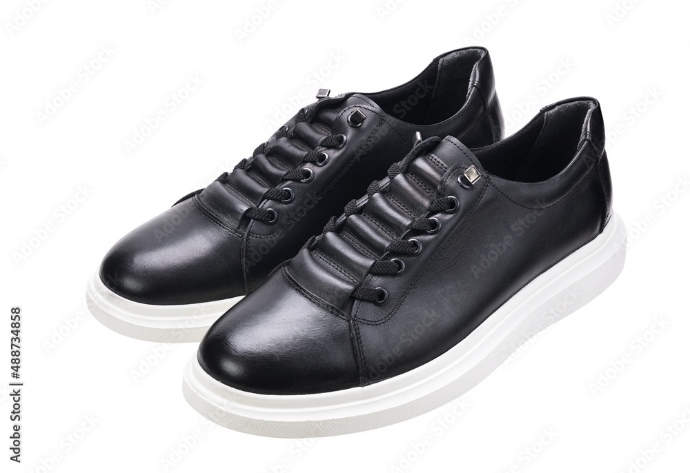 A pair of black sneakers with white soles isolated on a white background. A pair of black sneakers with white soles isolated on a white background.