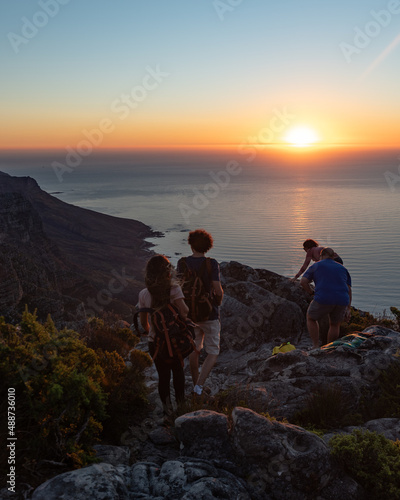 Couple hiking on mountain while the sun is setting. Hiking couple on a mountain enjoying sunset and the view of the sea at sunset.