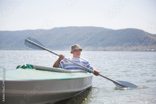  senior enjoying the day on the lake. Senior man enjoying kayaking on the river. Social Distancing. Digital detox. Staycations  hyper-local travel  family outing  getaway.