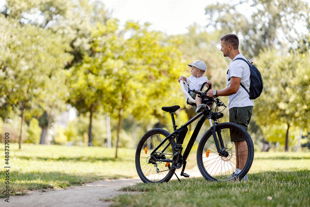 Father and little boy with bicycle on earth's day in nature taking a break.