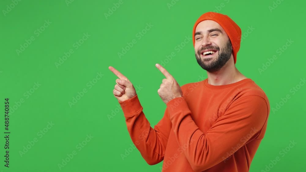 Promoter excited young brunet man 20s years old wears red shirt hat pointing fingers hands aside on workspace copy space mockup promo commercial area isolated on plain light green background studio Promoter excited young brunet man 20s years old wears red shirt hat pointing fingers hands aside on workspace copy space mockup promo commercial area isolated on plain light green background studio