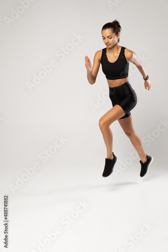 Full length photo of lady jump high up training marathon finish line wear sports suit isolated white background