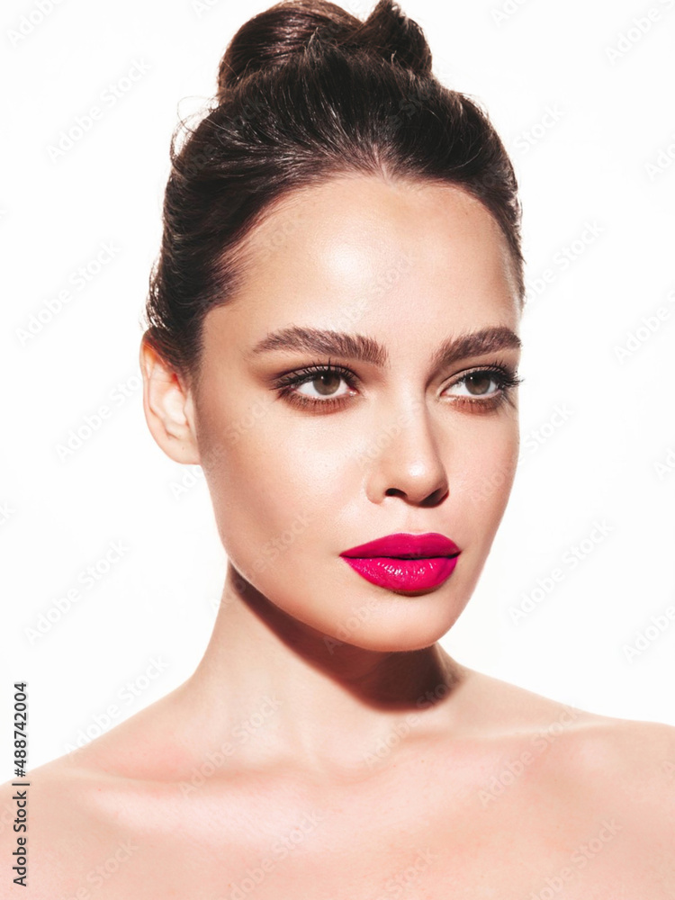 Fashion beauty portrait of young brunette woman with evening stylish makeup and perfect clean skin. Sexy model with hair in a bun posing in studio. With pink bright natural lips. Isolated on white Fashion beauty portrait of young brunette woman with evening stylish makeup and perfect clean skin. Sexy model with hair in a bun posing in studio. With pink bright natural lips. Isolated on white