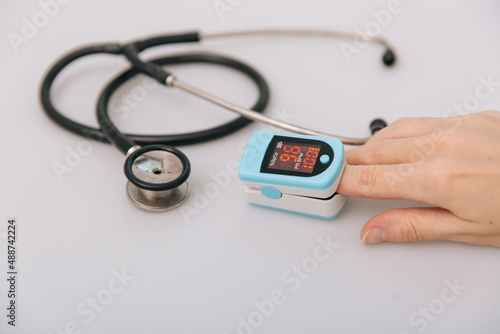 Stethoscope, pulse oximeter and thermometer gun on white background. Phonendoscope. Infrared isometric thermometer gun to check body temperature for virus symptoms. Treatment of cold or flu.