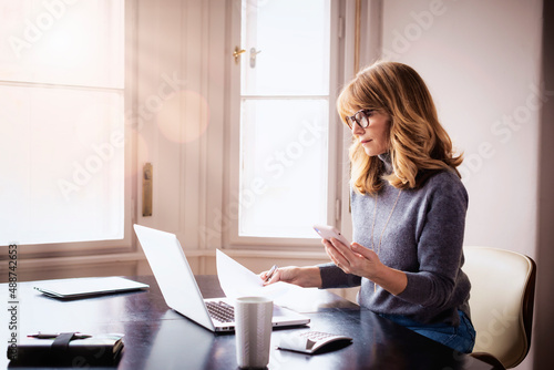 Confident businesswoman sitting behind her laptop while working from home