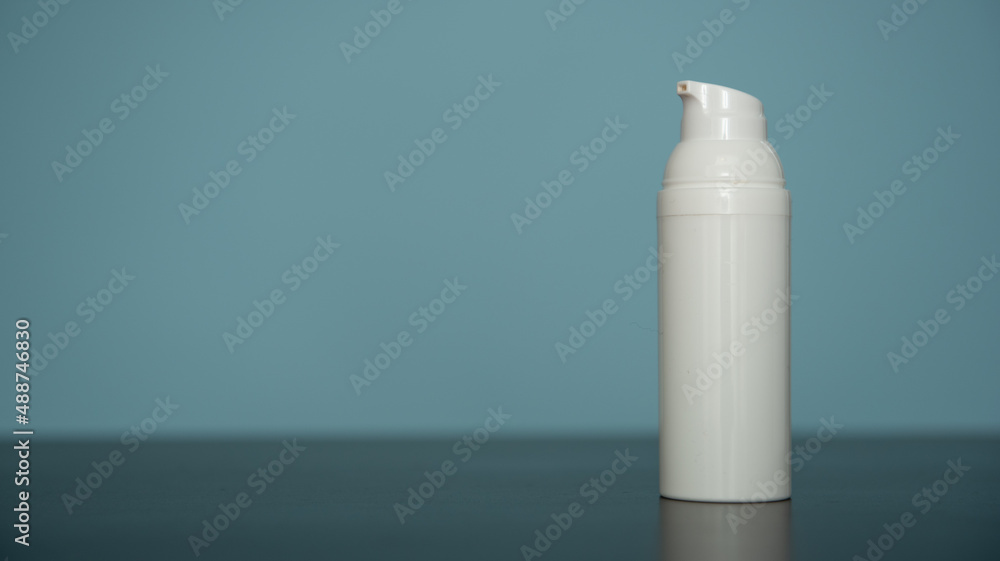 Flacon de crème pour visage en plastique blanc sur fond bleu - mockup pour produit cosmétique Flacon de crème pour visage en plastique blanc sur fond bleu - mockup pour produit cosmétique