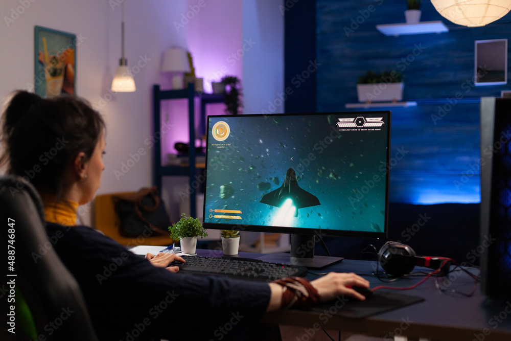 Adult playing video games on monitor with mouse and headphones. Gamer using  mousepad and headset to play online games on computer. Player having fun  with gaming and electronic game Stock Photo