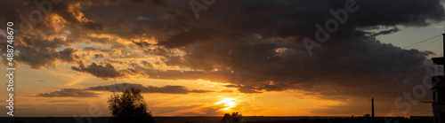 Landscape at sunset. Tragic gloomy sky. The village in the Budjak steppe. Panorama. Crimson twilight.