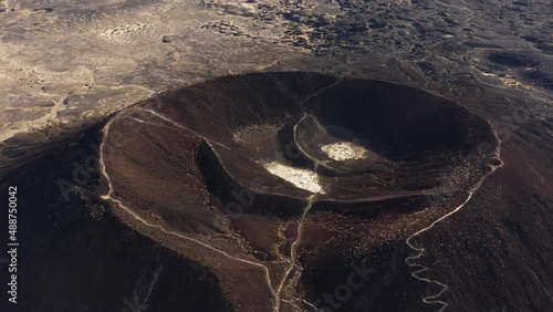 Cinematic aerial view of Amboy Crater dormant cinder cone volcano in the eastern Mojave Desert of southern California, Route 66 travel destination for adventurer trekkers photo
