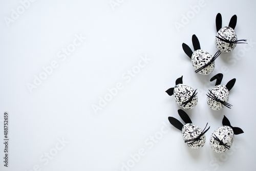 Easter eggs decorated as black and white spotted bunnies on the white background, copy space. photo