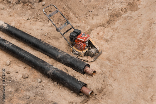 Repair of the water line of the heating main pipe in the ground trench pipeline at the construction site work industry, soil compaction pneumatic rammer