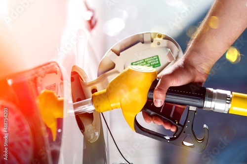 Young man, fill diesel tank of car after finish refill diesel oil in gas station photo