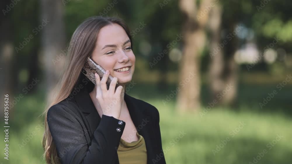 A young student talking on the phone in the park. A young student talking on the phone in the park.
