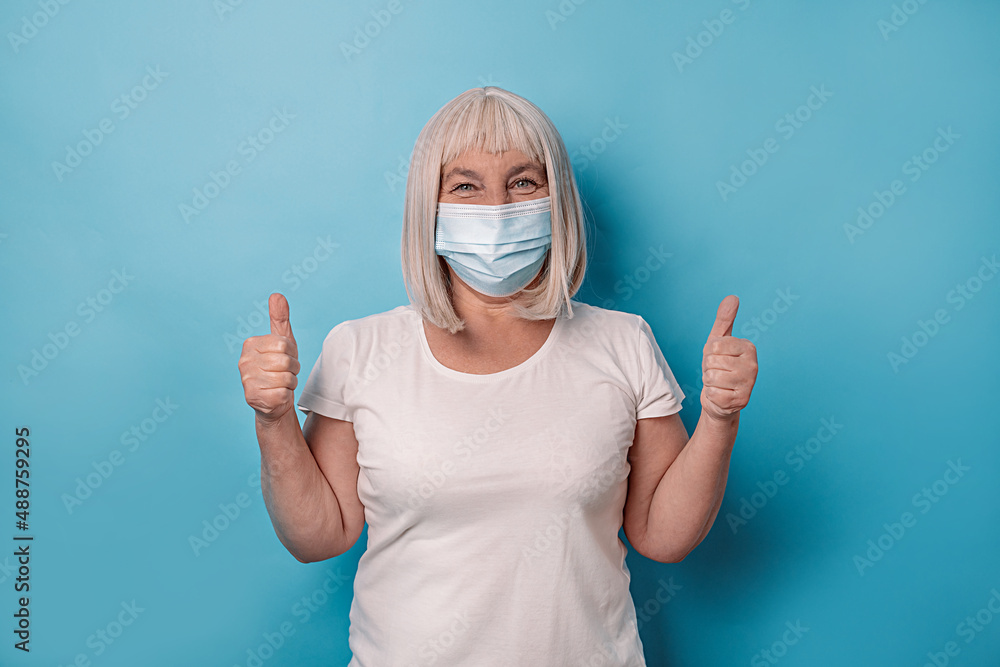 Happy woman showing Thumb sign after receiving covid 19 vaccine. Vaccine and old elder people inoculation. Coronavirus pandemic Happy woman showing Thumb sign after receiving covid 19 vaccine. Vaccine and old elder people inoculation. Coronavirus pandemic