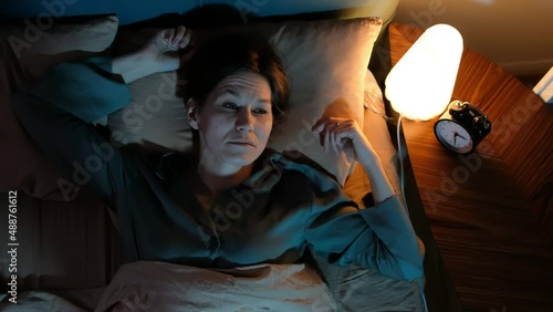 Depressed sad frustrated woman cannot sleep from insomnia, suffering from insomnia lying in bed.