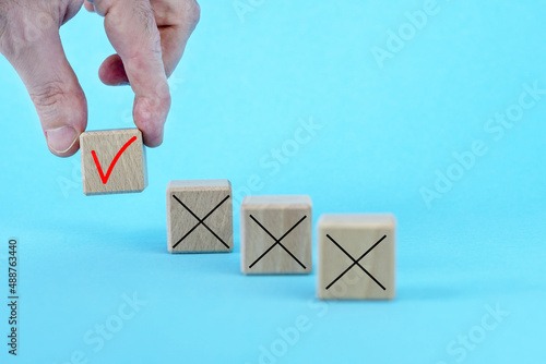 Hand takes wooden cube with Check mar