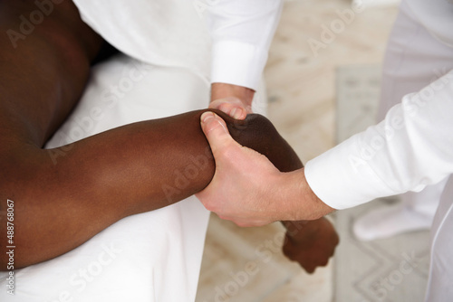 African american man having massage in spa, white background. Copy space