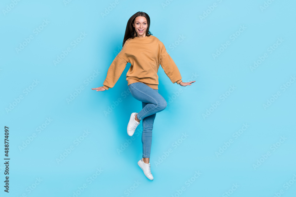 Fototapeta premium Full length photo of cool young brunette lady jump wear sweater jeans shoes isolated on blue background