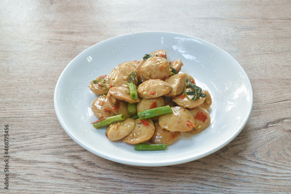 spicy stir fried slice pork meatball with yard long bean and basil leaf on plate spicy stir fried slice pork meatball with yard long bean and basil leaf on plate