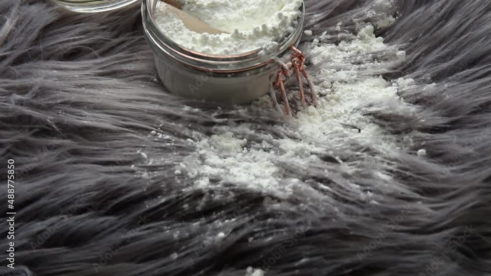 Pouring corn starch cornflour powder on long hair fur carpet for