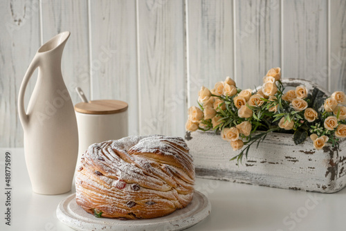 Krafin stands on a white wooden tray, next to it is a jug and flowers in a white wooden box. photo