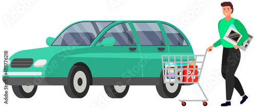 Man with purchases in supermarket trolley stands near car in parking lot, buyer with goods. Shopping concept, person with grocery basket loads purchases into trunk near store isolated on white