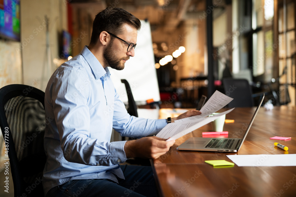 Young businessman using laptop in his office. Handsome man working on the project. Young businessman using laptop in his office. Handsome man working on the project.