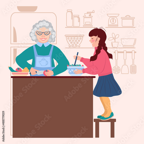 Granddaughter helps grandmother in the kitchen. Little girl is stirring the salad. Elderly woman cuts vegetables. Silhouette of a refrigerator and kitchen utensils in the background. Housework.
