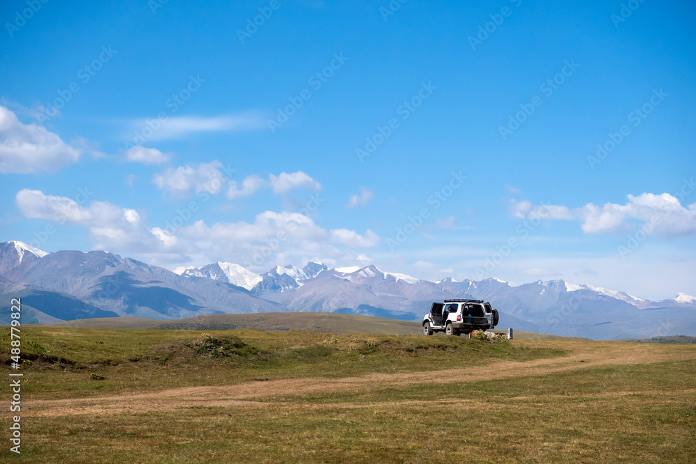 4x4 offroad vehicle with mountains and cloudy sky background. Summer road trip concept.
