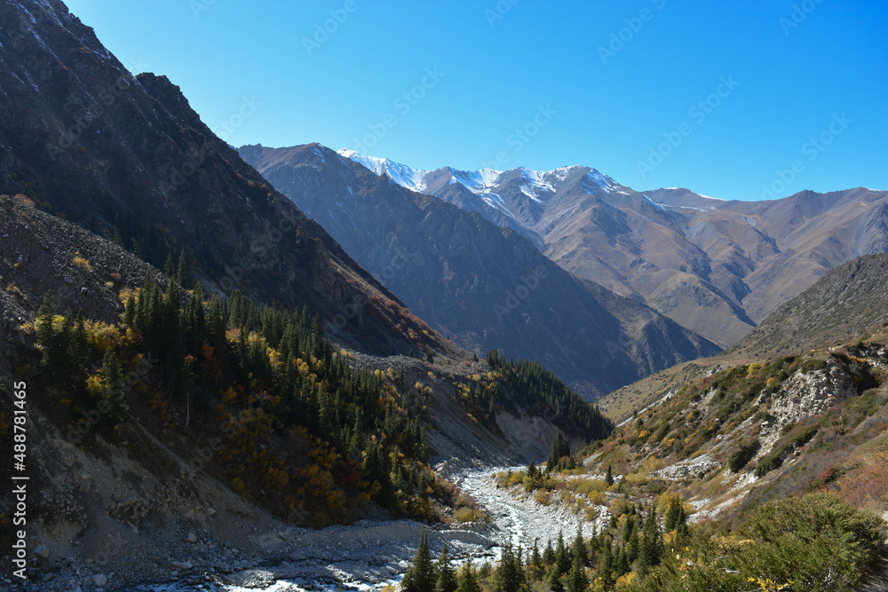landscape in autumn mountain peaks with blu sky with snow with stones in dry river  in central asia kyrgyzstan