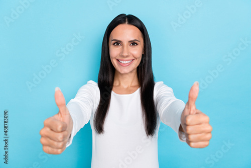 Photo of young cheerful girl show thumbs-up good ideal advert select quality isolated over blue color background © deagreez