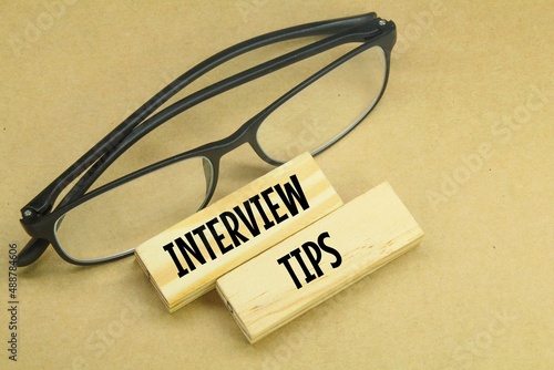 glasses and a wooden board with the words INTERVIEW TIPS. the concept of finding workers