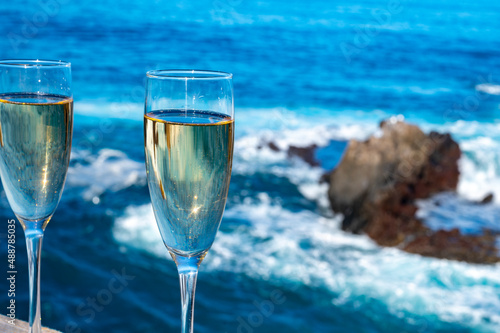 New year celebration with two glasses of champagne or Spanish cava sparkling wine and view on blue Atlantic ocean, Canary islands, winter tourists destination
