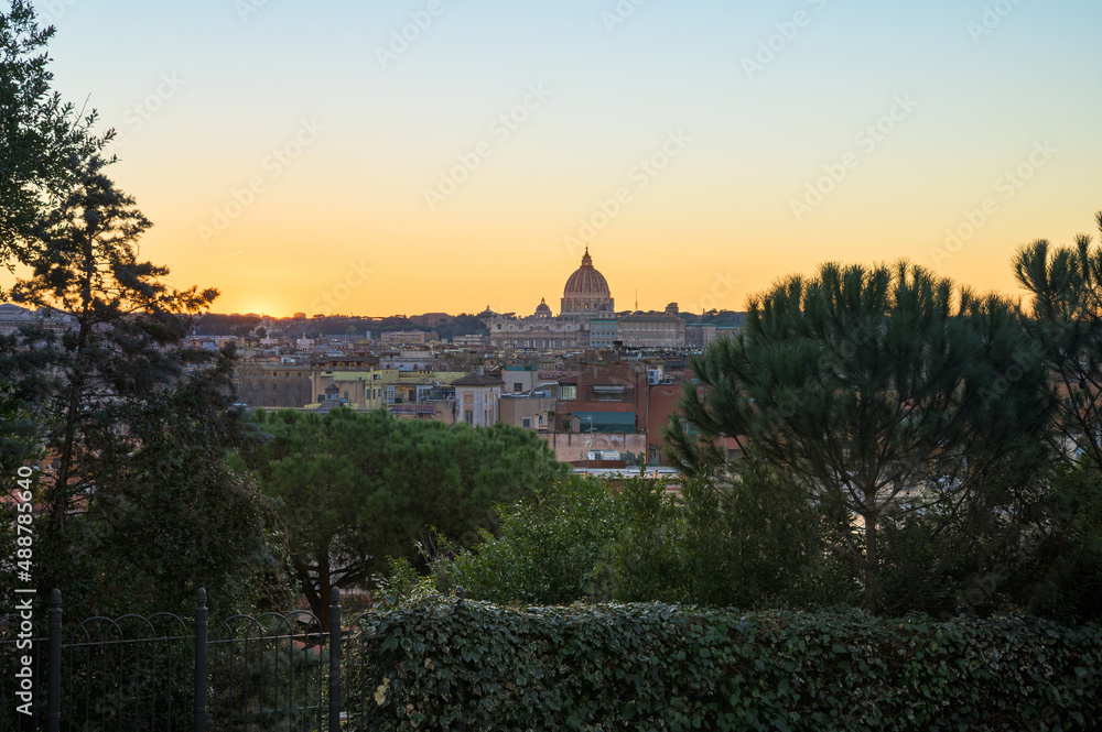 View of Rome skyline and the Vatican at sunset, with Saint Peter basilica's cupola as a silhouette from Pincio viewpoint, Italy