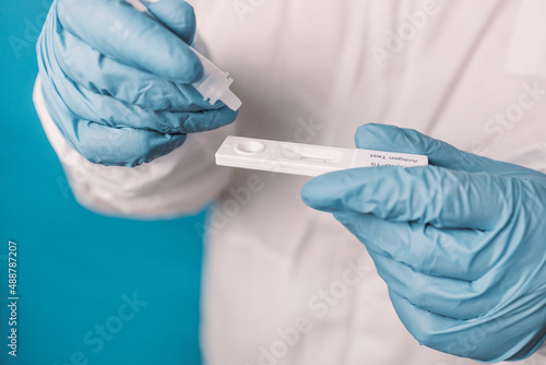 Принти на полотні Doctor in medical PPE suit using a covid-19 rapid antigen test, web banner