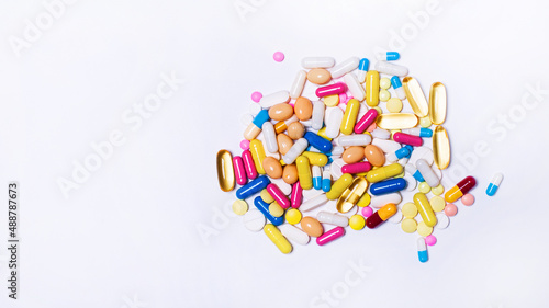 Various colorful pills and capsules on a white background. The concept of medicine and treatment. Copy space
