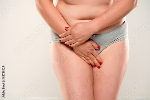 Woman in underwear placing her hands of her intima, isolated on white background.  photo