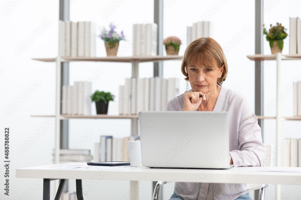 senior woman using laptop computer and serious at work
