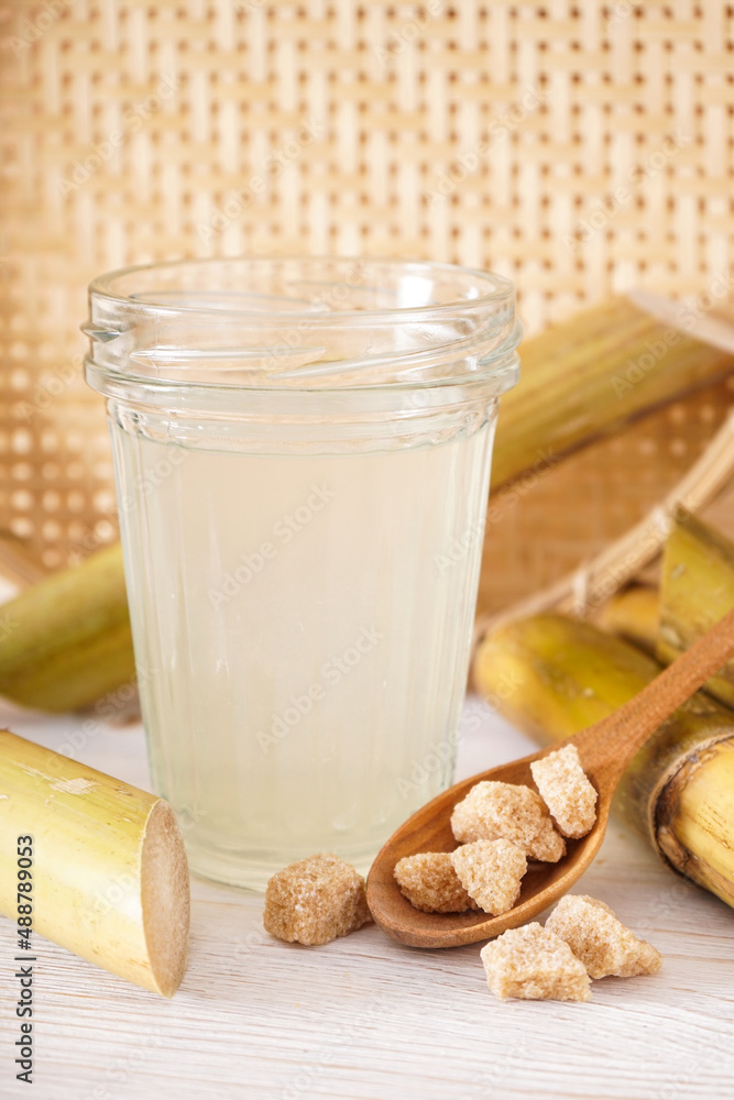 Fresh cane juice and granulated brown sugar on light background. Fresh cane juice and granulated brown sugar on light background.