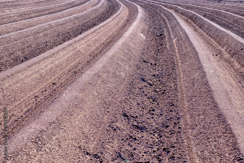 Plowed field furrows and dry soil